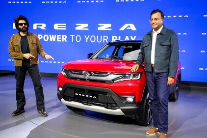 Bollywood actor Kartik Aaryan, left, poses for photographs next to a Brezza model at the Maruti stall during Bharat Mobility Global Expo 2025, in New Delhi. (PTI) Bollywood actor Kartik Aaryan, left, poses for photographs next to a Brezza model at the Maruti stall during Bharat Mobility Global Expo 2025, in New Delhi. (PTI)