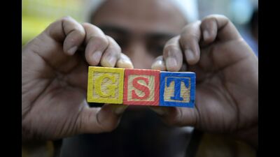 An Indian consumer goods trader shows letters GST representing "Goods and Services Tax" (GST)at his shop in Hyderabad on August 3, 2016. / AFP PHOTO / NOAH SEELAM (AFP)