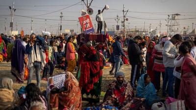 A Hindu devotee stands on top of a police check-post waving as he looks for his family members after taking a holy dip at Sangam, the confluence of the Ganges and Yamuna rivers with the mythical, invisible Saraswati river, during the Maha Kumbh. (REUTERS)