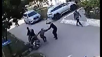 Video grab shows one of the accused attacking the victim with a sharp-edged weapon, while a pedestrian rushing away from the spot in the IT City area, Mohali. (HT Photo)