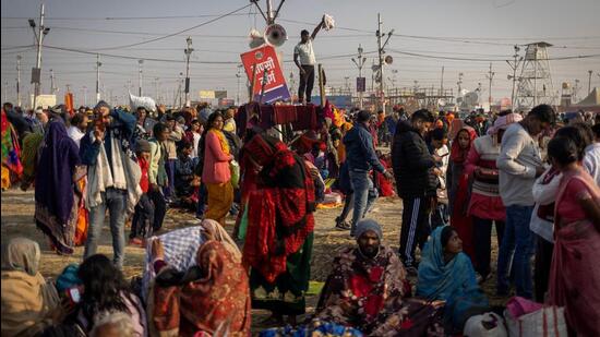 A Hindu devotee stands on top of a police check-post waving as he looks for his family members after taking a holy dip at Sangam, the confluence of the Ganges and Yamuna rivers with the mythical, invisible Saraswati river, during the Maha Kumbh. (REUTERS)