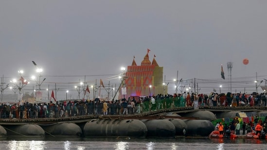 Hindu pilgrims walk on a floating pontoon bridge near Sangam, the confluence of the Ganges, Yamuna and mythical Saraswati rivers, during the ongoing Maha Kumbh Mela festival in Prayagraj. (AFP)