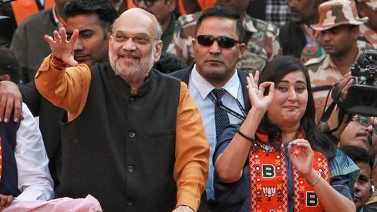 Union home minister and BJP leader Amit Shah with party MP Bansuri Swaraj during a roadshow in support of party candidate Neeraj Basoya ahead of Delhi assembly election in New Delhi on Tuesday (PTI)