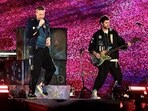 Musician Chris Martin (L) of the British band Coldplay, performs onstage during a concert at the D.Y. Patil stadium in Navi Mumbai.
