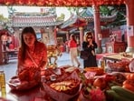 A woman makes an offering to gods as part of the traditional worship rituals on the eve of the Lunar New Year in Chinatown, Bangkok, Thailand. Forget the airport—Thailand’s new train network will link you straight to China!