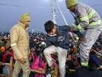 Security and UP Fire and Emergency Services personnel help a boy during a stampede-like situation on 'Mauni Amavasya', at the ongoing Maha Kumbh Mela.