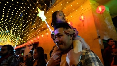 A resident Chinese carries his child as they walk in a street decorated with lights to welcome the Lunar New Year of the Snake, in Kolkata, India on Tuesday. People born in the Year of the Snake are often seen as resourceful, self-reliant, and determined to overcome challenges. Years of the Snake include 2025, 2013, 2001, 1989, 1977, 1965, and 1953, with the next Snake year in 2037. (AP)