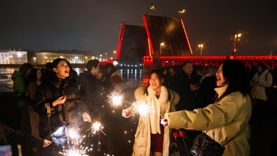 Revelers light sparklers near the Dvortsovy (Palace) Drawbridge on the Neva River raised and illuminated during Lunar New Year celebrations in St. Petersburg, Russia, early on Wednesday, Jan. 29, 2025. (AP)