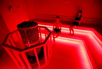 Staffs of teamLab wearing swimming suits use a sauna during a demonstration of TikTok teamLab Reconnect, digital artwork combined with sauna, ahead of its opening to the public this month in Tokyo, Japan, March 13, 2021. (REUTERS)