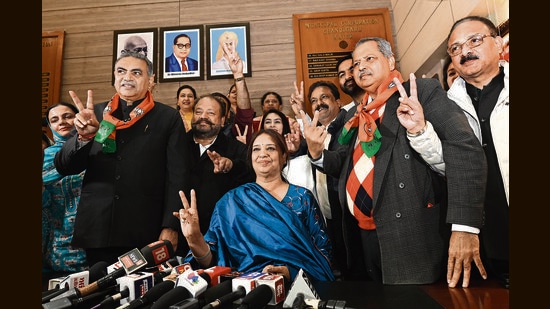 Newly elected mayor Harpreet Kaur Babla flanked by her husband, Devinder Singh Babla (left), and party’s local unit president Jatinder Pal Malhotra after her win at the MC office in Chandigarh. (Ravi Kumar/HT)