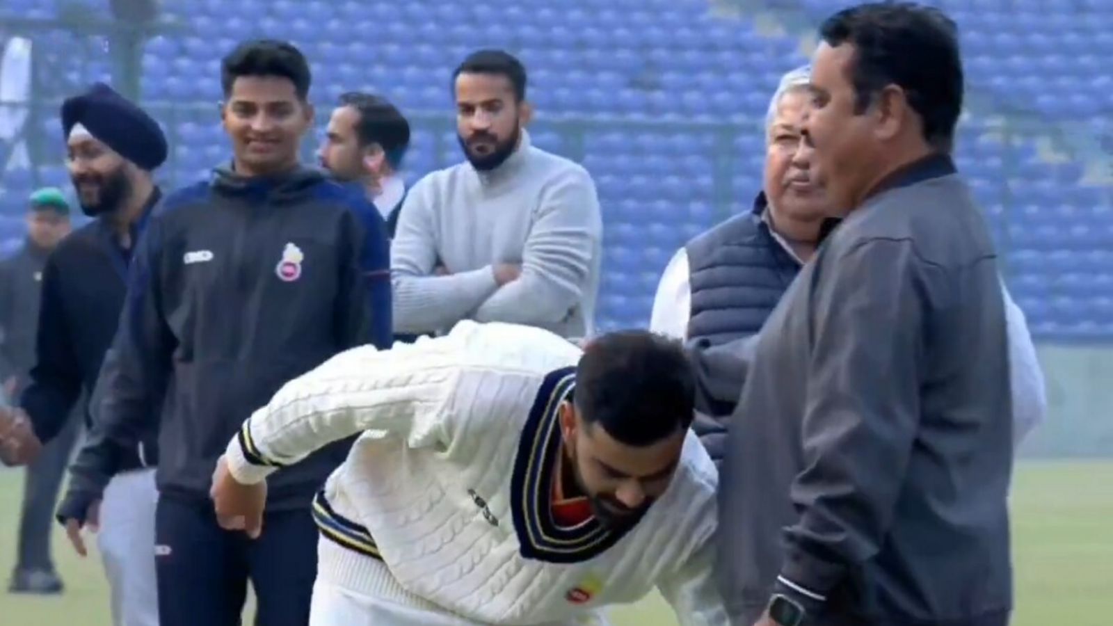 Virat Kohli çocukluk koçunun ayaklarına dokunuyor ve Ranji Trophy'de oyunun bitiminden sonra 100 test için Memento'ya bakıyor
