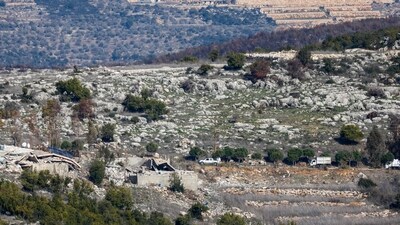 This picture taken from a position in northern Israel near the border with Lebanon, shows civilian Lebanese cars driving near destroyed buildings in the southern Lebanese village of Aita al-Shaab on January 29, 2025. (AFP/File)