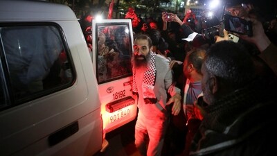 A freed Palestinian prisoner got out of the Red cross convoy wearing the symbolic keffiyeh and was welcomed by Gazans in Khan Younis. (Hatem Khaled/REUTERS)