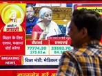 A man watches finance minister Nirmala Sitharaman presenting the Union Budget 2025-26 on television screens at a showroom, in Patna, Saturday, 