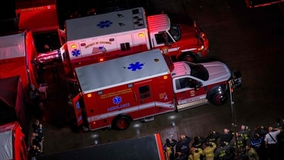 First responders salute the flag draped bodies of service members killed in a midair collision depart a temporary emergency disaster site at Buzzard Point (Getty Images via AFP)