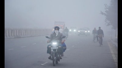 Commuters on their way to their destinations amid dense fog in Amritsar on Sunday. Sameer Sehgal/HT