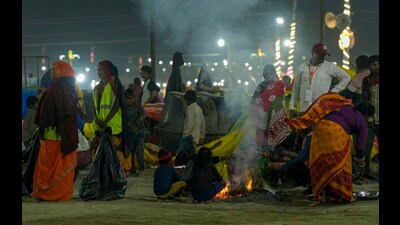 People sit near a bonfire during the ongoing Mahakumbh Mela 2025 in Prayagraj on Sunday. (PTI) People sit near a bonfire during the ongoing Mahakumbh Mela 2025 in Prayagraj on Sunday. (PTI)