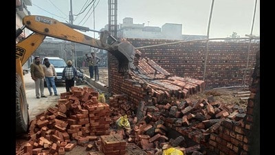 MC officials getting demolished an under-construction building in Shimlapuri on Monday. (Manish/HT)