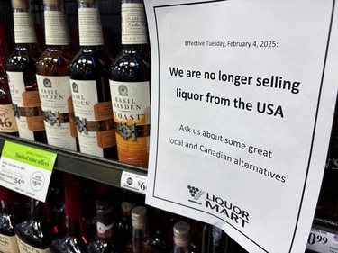A sign notifying customers that a store will stop selling U.S. liquor from Tuesday, in response to U.S. President Donald Trump's imposition of tariffs on Canada, is displayed on a shelf carrying U.S. alcohol in Winnipeg, Manitoba, Canada, February 2, 2025.   REUTERS/Ed White (REUTERS)