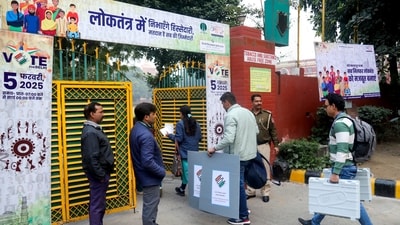 Polling officials carrying EVMs and other election materials arrive at a polling centre at Gole Market ahead of Delhi assembly election in New Delhi on Tuesday. (PTI) Polling officials carrying EVMs and other election materials arrive at a polling centre at Gole Market ahead of Delhi assembly election in New Delhi on Tuesday. (PTI)