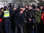 Sweden's Prime Minister Ulf Kristersson (C) passes under the police cordon to return to the site, the adult education center Campus Risbergska school in Orebro, Sweden, on February 5, 2025  one day after a shooting at the adult education center Campus Risbergska school, where eleven people were killed (Photo by Jonathan NACKSTRAND / AFP)