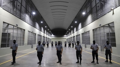 Prison guards stand outside holding cells during a media tour of the Terrorism Confinement Center, or CECOT, in Tecoluca, El Salvador, Feb. 2, 2023. (AP Photo/Salvador Melendez, File) (AP)