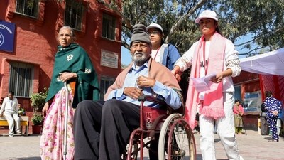 A senior citizen receives assistance to reach the polling booth and cast his vote during the Delhi Assembly elections on Wednesday. (PIB) A senior citizen receives assistance to reach the polling booth and cast his vote during the Delhi Assembly elections on Wednesday. (PIB)