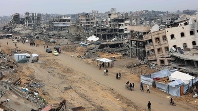 People walk amid collapsed buildings along Saftawi street in Jabalia in the northern Gaza Strip on February 5, 2025 during a ceasefire deal in the war between Israel and Hamas went into effect. (Photo by Omar AL-QATTAA / AFP) (AFP) People walk amid collapsed buildings along Saftawi street in Jabalia in the northern Gaza Strip on February 5, 2025 during a ceasefire deal in the war between Israel and Hamas went into effect. (Photo by Omar AL-QATTAA / AFP) (AFP)