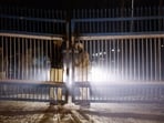 Policemen stand guard at the gate as police vehicles transporting Indian immigrants deported from the US leave the airport in Amritsar, India February 5, 2025. 