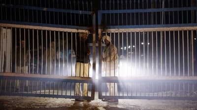 Policemen stand guard at the gate as police vehicles transporting Indian immigrants deported from the US leave the airport in Amritsar, India February 5, 2025. (REUTERS)