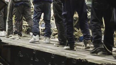 Indians in shackles being escorted to a flight for deportation from the US. (Screengrab) Indians in shackles being escorted to a flight for deportation from the US. (Screengrab)