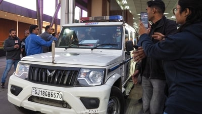 Members of media gather around a police car transporting Indian migrants deported by the United States, at the airport in Ahmedabad on February 6, 2025. (AFP) Members of media gather around a police car transporting Indian migrants deported by the United States, at the airport in Ahmedabad on February 6, 2025. (AFP)