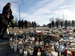 People stand next to candles and flowers placed near the Risbergska school, following a deadly shooting attack at the adult education centre, in Orebro, Sweden