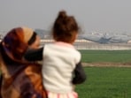 People look at a US military plane deporting Indian immigrants as it lands in Amritsar. 