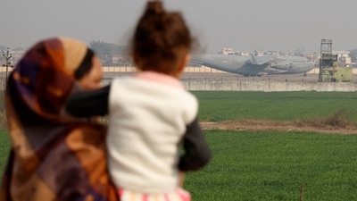People look at a US military plane deporting Indian immigrants as it lands in Amritsar. (REUTERS)
