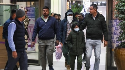 Security personnel escort Indian immigrants deported from the U.S., as they leave the airport in Ahmedabad, India. (REUTERS)