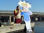 BJP candidate from the New Delhi assembly constituency Parvesh Verma submerges a cut-out of AAP national convener Arvind Kejriwal in the Yamuna River to protest over the issue of cleaning the Yamuna. (HT Photo)