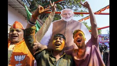 BJP supporters celebrating the party’s performance in the assembly elections in New Delhi on Saturday. (PTI Photo)