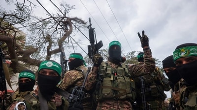 Hamas fighters secure an area before handing over three Israeli hostages to a Red Cross team in Deir el-Balah, central Gaza, on Saturday. (AFP) Hamas fighters secure an area before handing over three Israeli hostages to a Red Cross team in Deir el-Balah, central Gaza, on Saturday. (AFP)