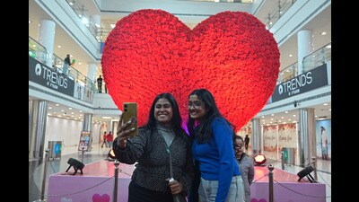 People pose with the 10-foot heart at Saharaganj mall in Lucknow on Saturday. (HT Photo)