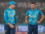 England's captain Jos Buttler, left, talks to Mark Wood during the second one day international cricket match between India and England in Cuttack.