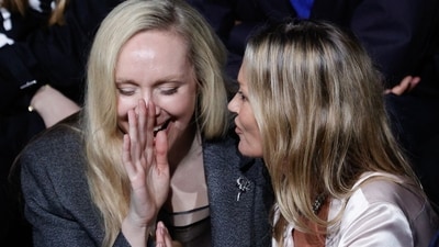 British actress Gwendoline Christie (L) shares a light moment with British model Kate Moss (R) as they sit front row during of the Dior Menswear Ready-to-wear Fall-Winter 2025/2026 collection as part of the Paris Fashion Week, in Paris on January 24, 2025. (Photo by GEOFFROY VAN DER HASSELT / AFP) (AFP)