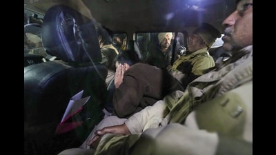 Police personnel take away deported immigrants from the Shri Guru Ramdas Ji International Airport, in Amritsar. (PTI)