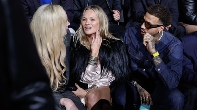 TOPSHOT - (From L) British actress Gwendoline Christie, British model Kate Moss and US fencer Miles Chamley-Watson sit front row during of the Dior Menswear Ready-to-wear Fall-Winter 2025/2026 collection as part of the Paris Fashion Week, in Paris on January 24, 2025. (Photo by GEOFFROY VAN DER HASSELT / AFP) (AFP)