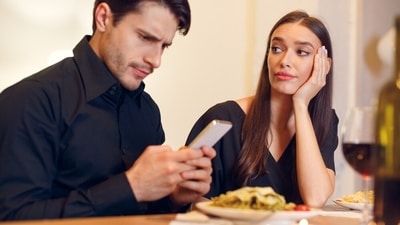 Don't let phone meddle and third wheel on your dinner date. (Shutterstock)