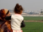 A mother and child look at the US military plane deporting Indian immigrants as it lands in Amritsar earlier this month. (REUTERS)