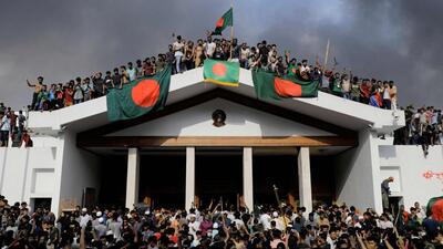 Anti-government protestors display Bangladesh's national flag as they storm Prime Minister Sheikh Hasina's palace in Dhaka on August 5 (AFP FILE) Anti-government protestors display Bangladesh's national flag as they storm Prime Minister Sheikh Hasina's palace in Dhaka on August 5 (AFP FILE)