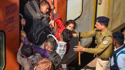 A RPF personnel tries to manage as passengers jostle to board a train amid a massive rush to reach the Maha Kumbh Mela 2025 on 'Maghi Purnima', at Patna railway station, Wednesday, Feb. 12, 2025. (PTI) A RPF personnel tries to manage as passengers jostle to board a train amid a massive rush to reach the Maha Kumbh Mela 2025 on 'Maghi Purnima', at Patna railway station, Wednesday, Feb. 12, 2025. (PTI)