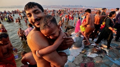 A devotee holds a child as they leave after taking a dip at Sangam, the confluence of the Ganges and Yamuna rivers with the mythical invisible Saraswati river, to mark Maghi Purnima, one of the auspicious days during the Mahakumbh Mela. (REUTERS)