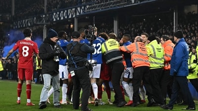 Liverpool's English midfielder #17 Curtis Jones is held back by stewards as he remonstrates with Everton players (AFP)